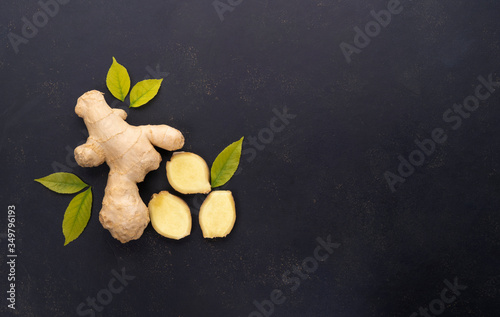 Flat lay fresh raw ginger root on dark background.