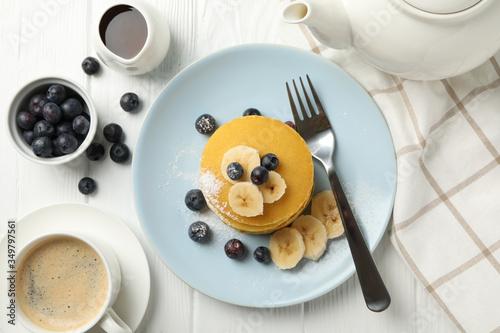 Composition with pancakes, banana and blueberry on wooden background. Sweet breakfast