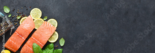 Panel kuchenny z motywem Slice of salmon filet with lemon, basil and spices on a black background.Flatly food