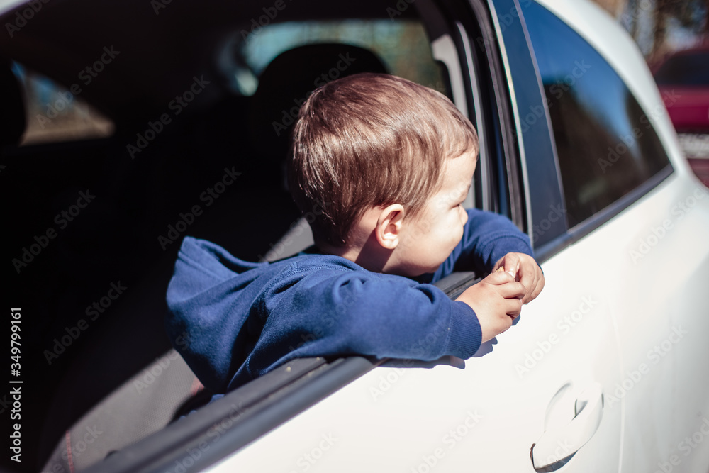 Little boy peeps out of a car window Little boy peeps out of a car window
