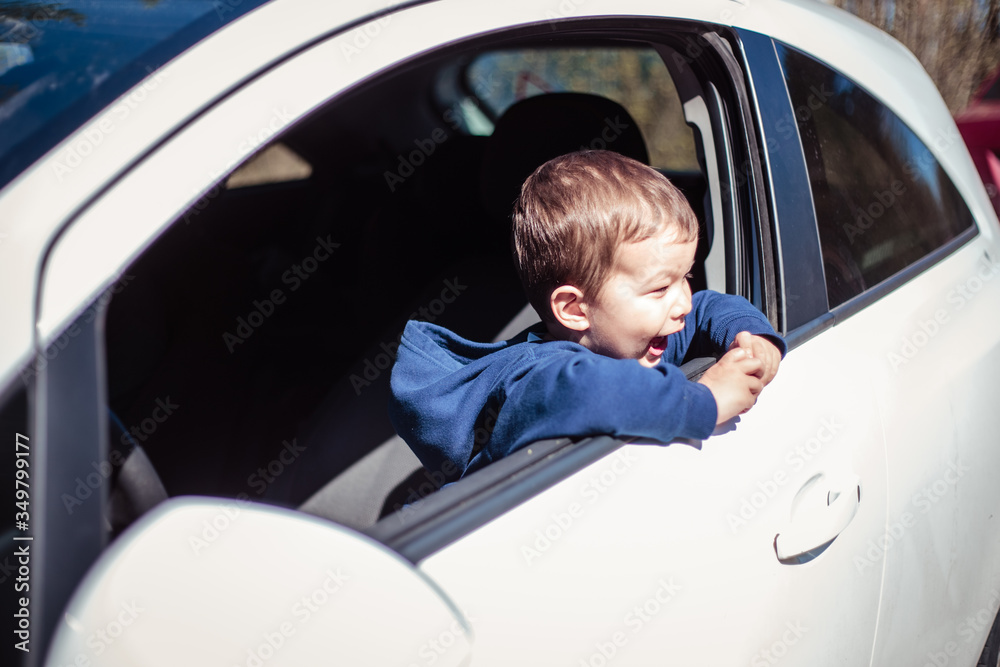 Little boy peeps out of a car window Little boy peeps out of a car window