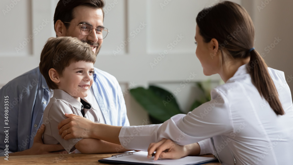 Caring female doctor or nurse comfort cheer little boy patient at consultation in hospital, attentive woman pediatrician show support to small child do checkup at clinic, children healthcare concept