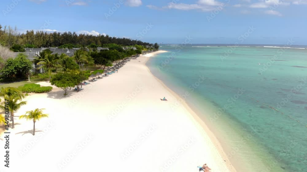 Tropical beach in Le Morne at Mauritius island. Beach with palms and blue transparent ocean. Aerial view Tropical beach in Le Morne at Mauritius island. Beach with palms and blue transparent ocean. Aerial view
