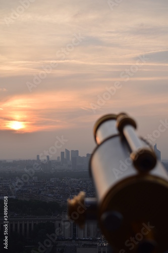 Atardecer de la ciudad de Paris desde la Torre Eiffel con telescopio en primer plano desenfocado