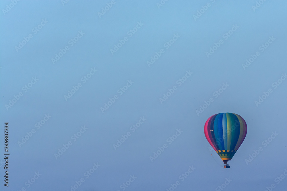 Globo aerostático de colores volando con un cielo azul Globo aerostático de colores volando con un cielo azul