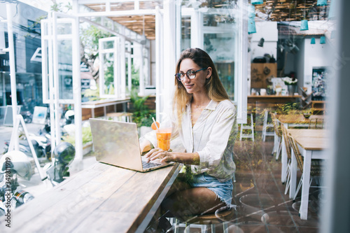 Woman checking email on laptop in restaurant