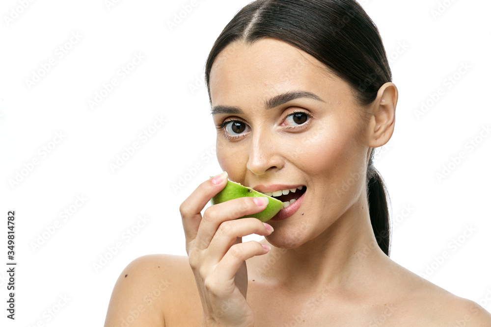 close-up portrait of a girl with clear skin holding a apple to her face, isolated on a white background close-up portrait of a girl with clear skin holding a apple to her face, isolated on a white background