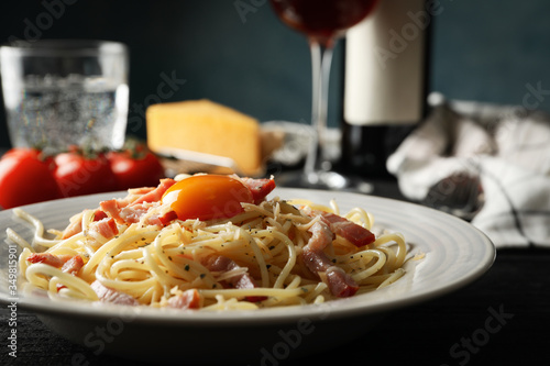 Composition with plate of tasty pasta on wooden background, close up