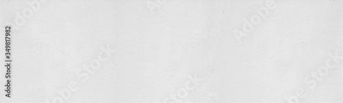 White washed rough plastered wall wide texture. Light painted textured cement surface. Whitewashed abstract widescreen background