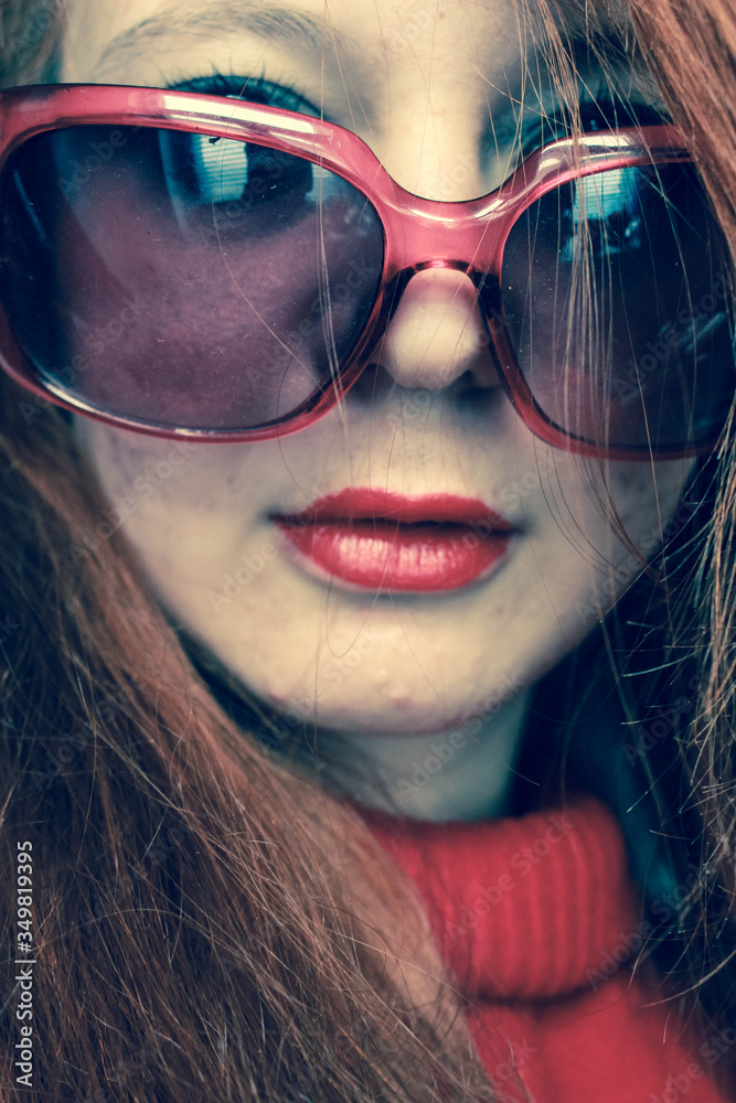 Portrait of a stylish sexy girl with red hair, red lipstick, in red glasses Portrait of a stylish sexy girl with red hair, red lipstick, in red glasses