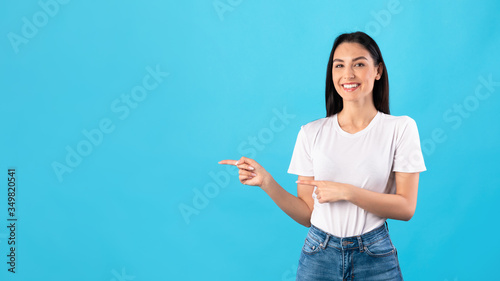 Happy woman pointing fingers at copy space