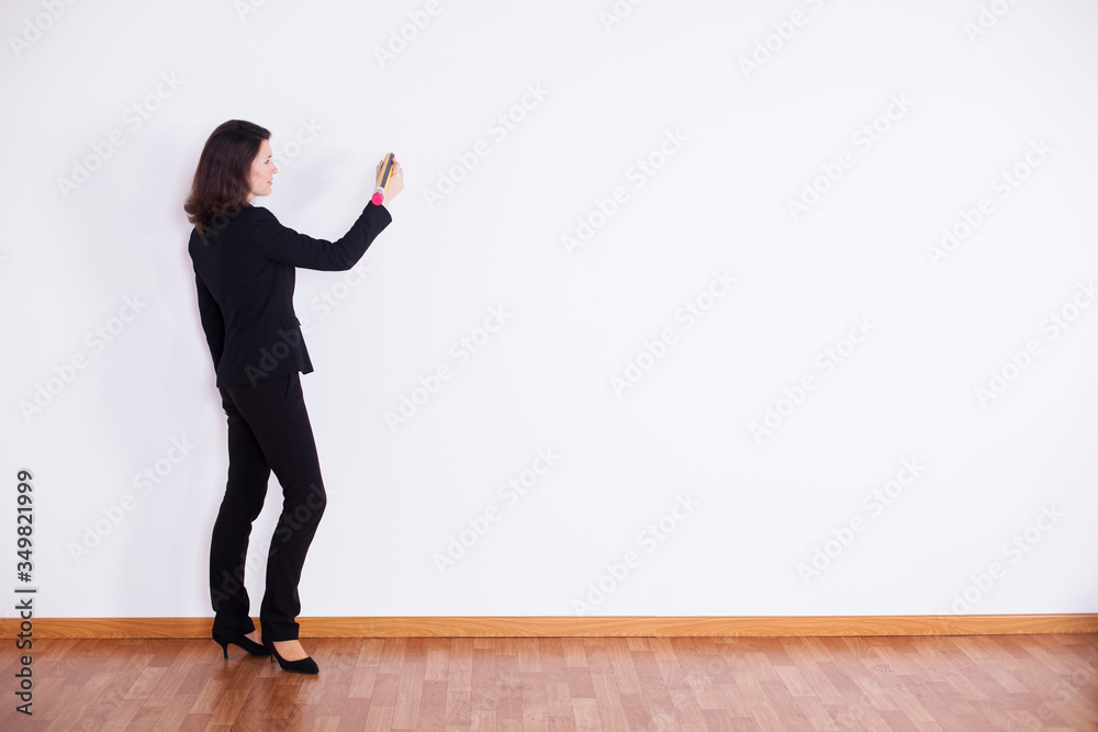 Businesswoman writing on the wall Businesswoman writing on the wall