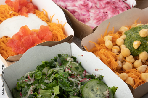 a set of different salads for vegetarians and raw foodists ready to eat in cardboard plates photo