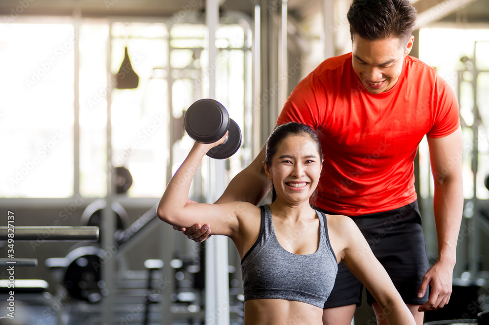 Obraz premium The trainer is teaching exercise to charming women Dumbbell Lifting Course for Strengthens Muscles, Online Live Streaming, Exercise Tutorials, Exercise Concept at Home.