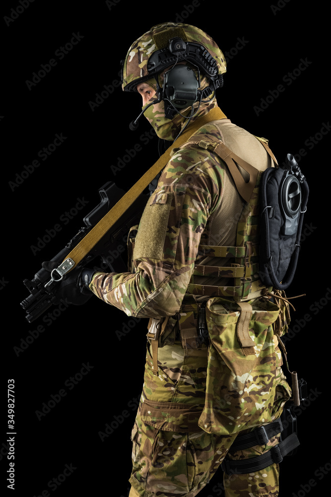 Soldier holding assault rifle. Uniform conforms to special services of the Russian Federation. Shot in studio. Isolated with clipping path on black background Soldier holding assault rifle. Uniform conforms to special services of the Russian Federation. Shot in studio. Isolated with clipping path on black background