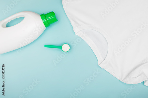 Washing liquid or stain remower, powder detergent and clean t-shirt on blue background.