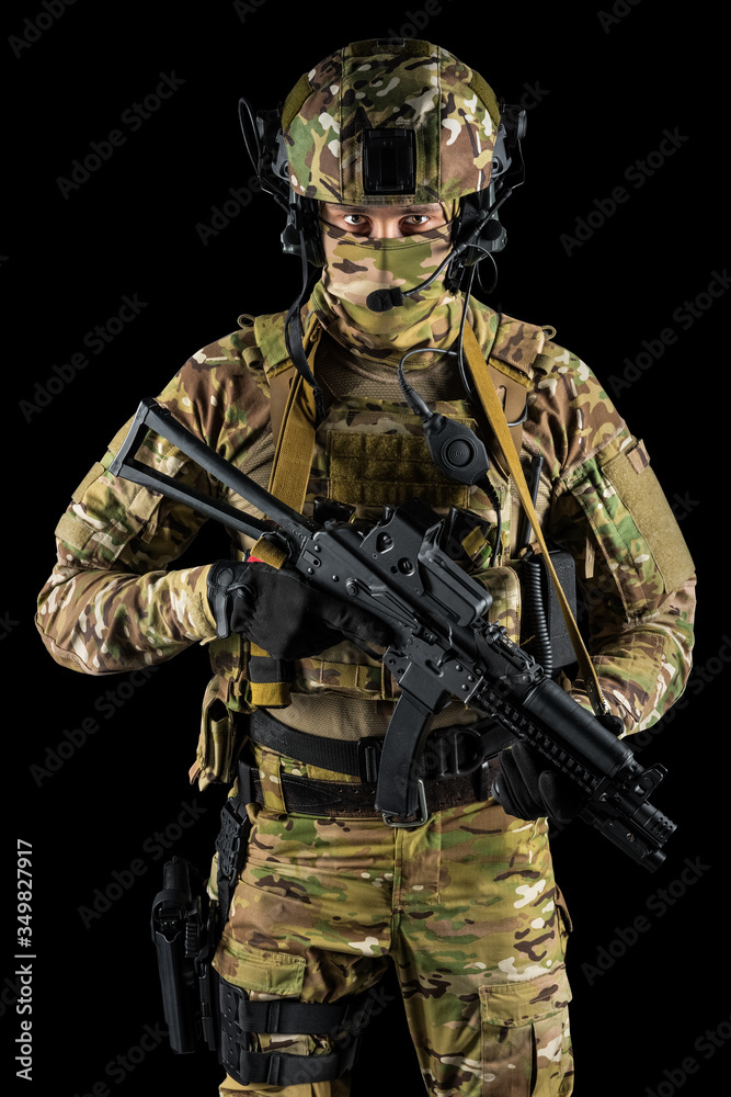 Soldier holding assault rifle. Uniform conforms to special services of the Russian Federation. Shot in studio. Isolated with clipping path on black background Soldier holding assault rifle. Uniform conforms to special services of the Russian Federation. Shot in studio. Isolated with clipping path on black background