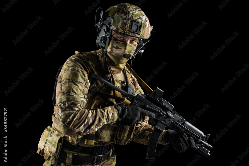 Soldier holding assault rifle. Uniform conforms to special services of the Russian Federation. Shot in studio. Isolated with clipping path on black background Soldier holding assault rifle. Uniform conforms to special services of the Russian Federation. Shot in studio. Isolated with clipping path on black background