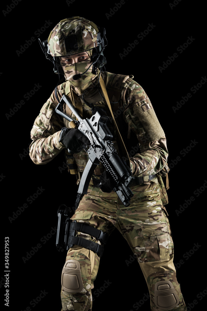 Soldier holding assault rifle. Uniform conforms to special services of the Russian Federation. Shot in studio. Isolated with clipping path on black background