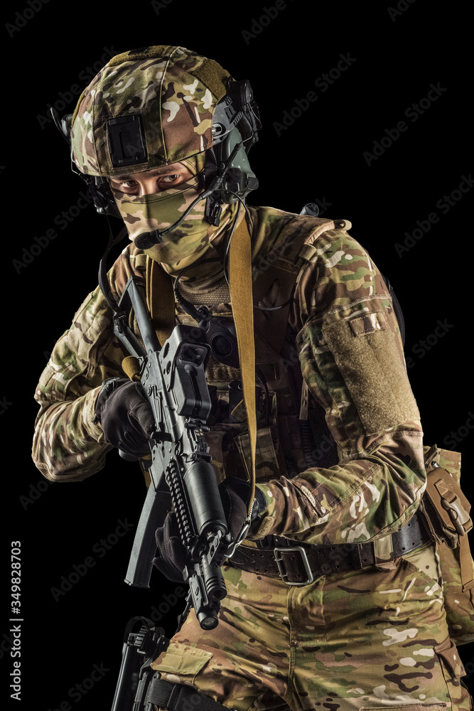 Soldier holding assault rifle. Uniform conforms to special services of the Russian Federation. Shot in studio. Isolated with clipping path on black background Soldier holding assault rifle. Uniform conforms to special services of the Russian Federation. Shot in studio. Isolated with clipping path on black background
