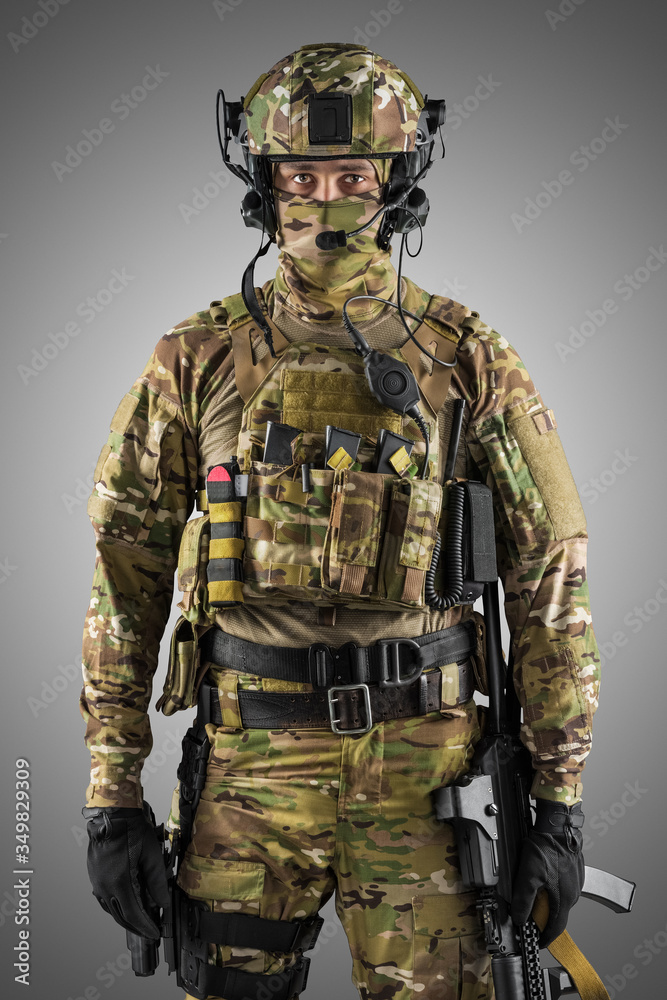 Soldier holding assault rifle. Uniform conforms to special services of the Russian Federation. Shot in studio. Isolated with clipping path on grey background Soldier holding assault rifle. Uniform conforms to special services of the Russian Federation. Shot in studio. Isolated with clipping path on grey background