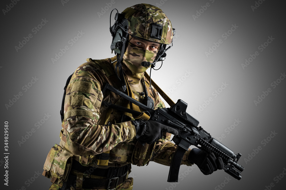 Soldier holding assault rifle. Uniform conforms to special services of the Russian Federation. Shot in studio. Isolated with clipping path on grey background Soldier holding assault rifle. Uniform conforms to special services of the Russian Federation. Shot in studio. Isolated with clipping path on grey background