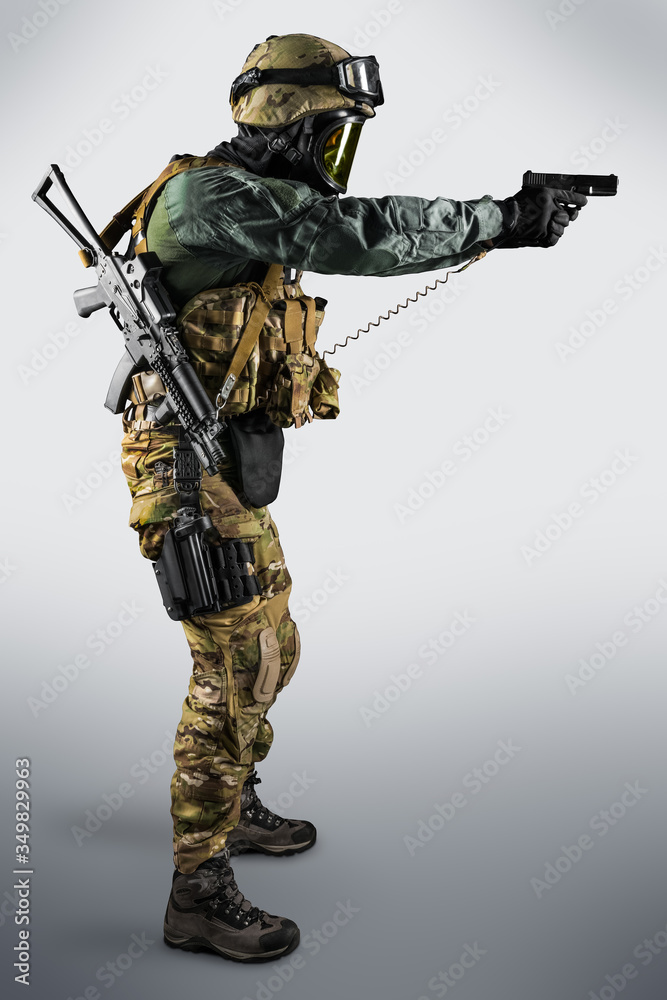 Soldier holding assault rifle. Uniform conforms to special services of the Russian Federation. Shot in studio. Isolated with clipping path on grey background Soldier holding assault rifle. Uniform conforms to special services of the Russian Federation. Shot in studio. Isolated with clipping path on grey background