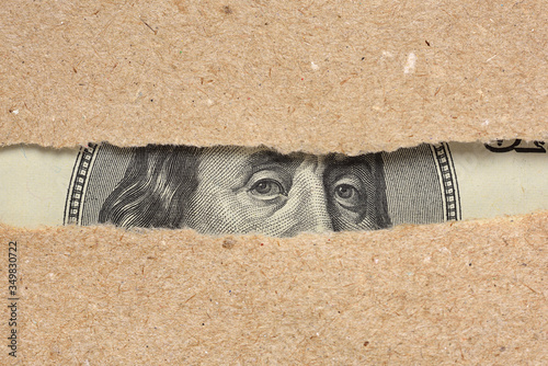 Obraz na plátne One hundred dollar bill behind brown craft ripped paper
