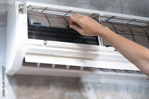 Close up woman hand open air conditioner filter for cleaning home air conditioner
