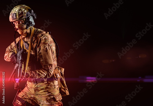 Soldier holding assault rifle. Uniform conforms to special services of the Russian Federation. Shot in studio. Isolated with clipping path on black background (flashing lights effect)