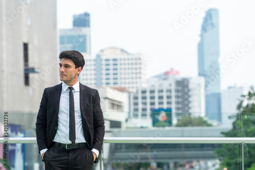 Quadro su tela Portrait of businessman in black suit in city finding job during crisis