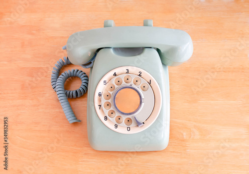 Old broken green rotary phone on wooden background. selective focus, retro and vintage style
