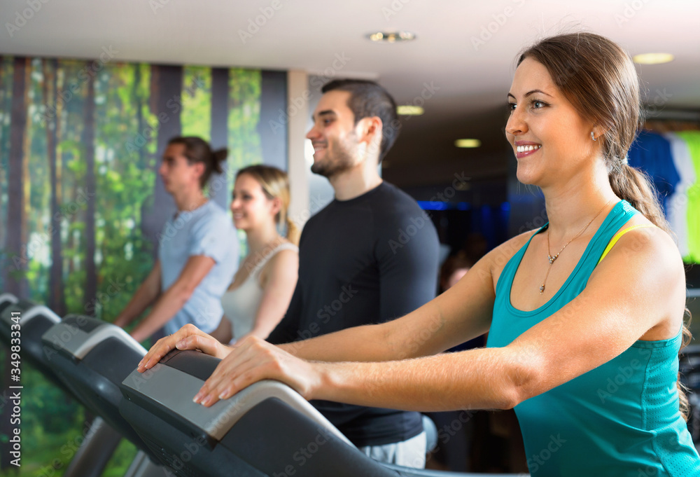 Group of people doing cardio on treadmills in fitness club