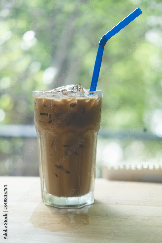 Iced Espresso coffee in a tall glass on wooden table.