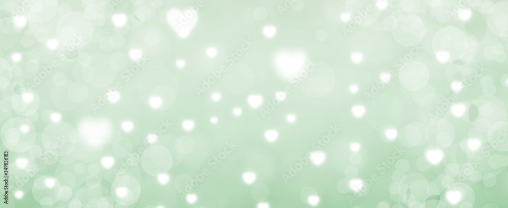 Glowing green bokeh background. Spring concept. Blurred bokeh circles and hearth shapes.  Website banner. Celebration.  Christmas.