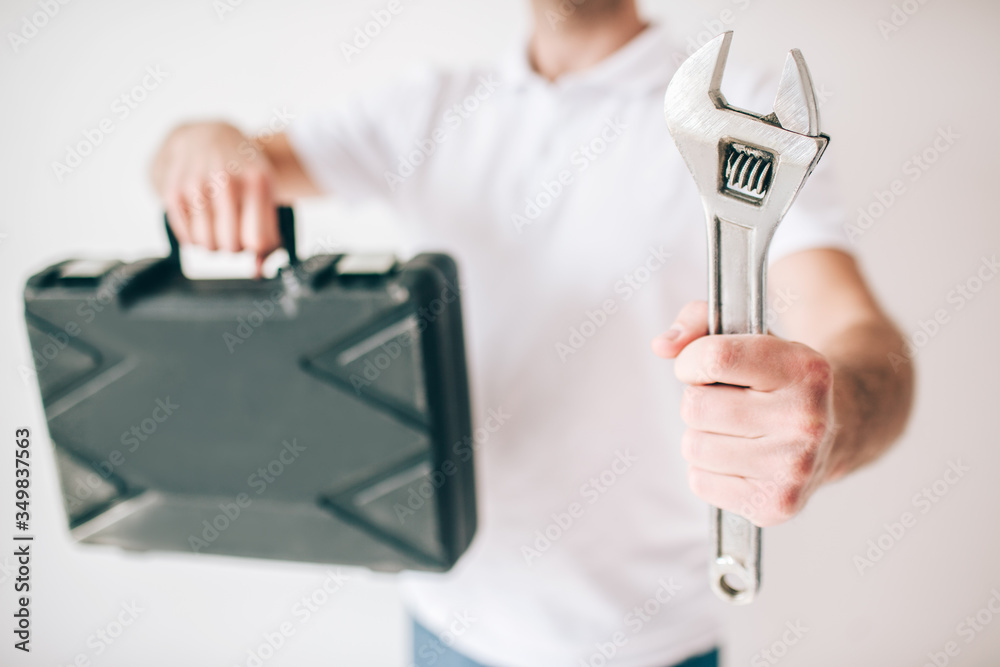 Young man isolated over white background. Cut view of guy holding box and wrench in hands. Repain man of fixing plumber. Young man isolated over white background. Cut view of guy holding box and wrench in hands. Repain man of fixing plumber.
