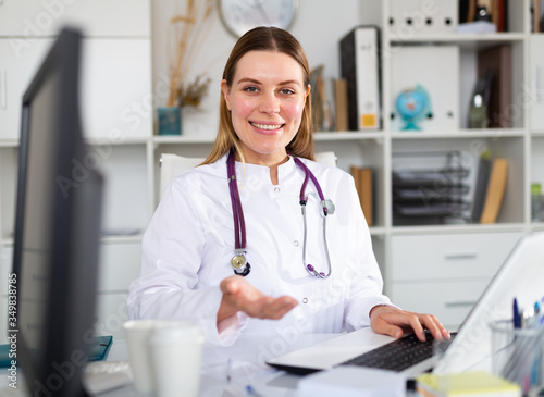 Female doctor working on laptop in clinic office