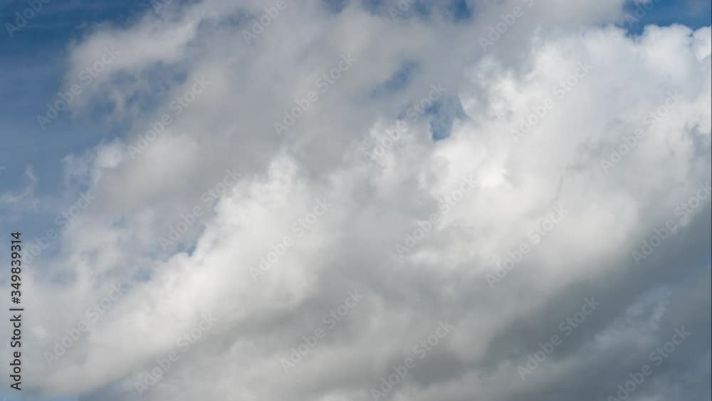 White fluffy clouds run across the blue sky in spring. Baltic state. Latvia White fluffy clouds run across the blue sky in spring. Baltic state. Latvia