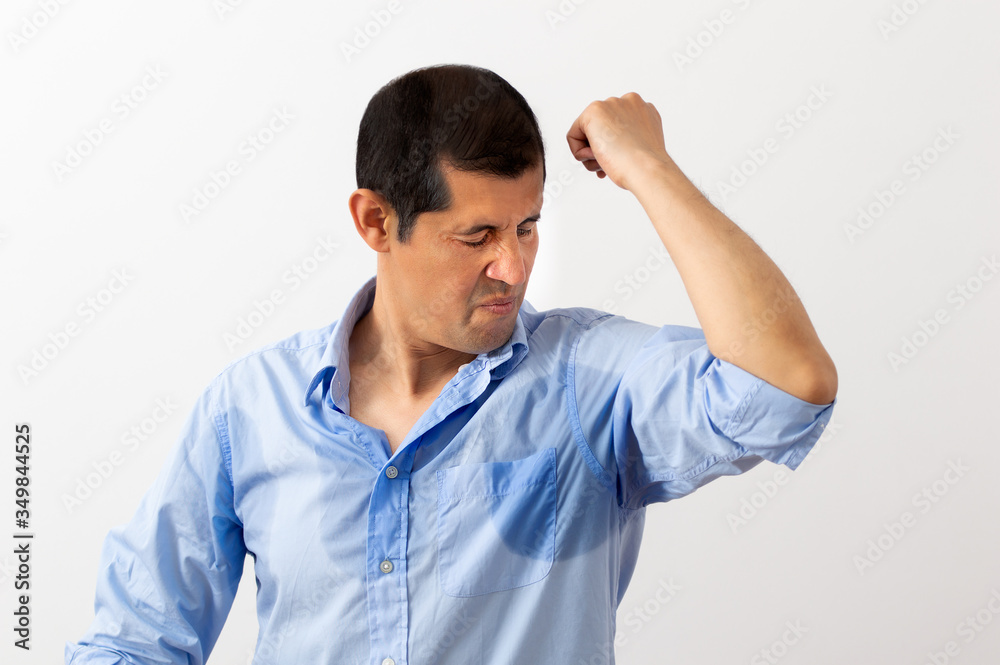 Shot of a handsome young man smelling his armpits at home Shot of a handsome young man smelling his armpits at home