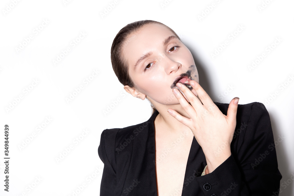 A girl in a black jacket smears lipstick on her face A girl in a black jacket smears lipstick on her face
