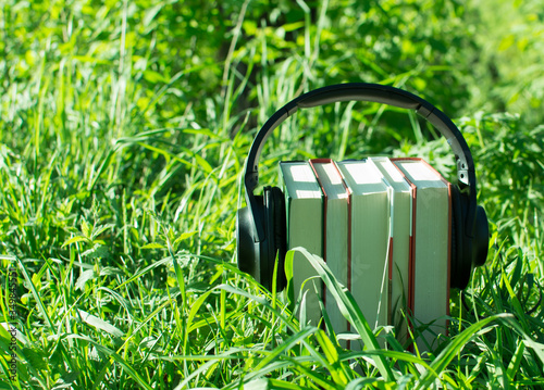 audiobook concept with headphones and books, in nature