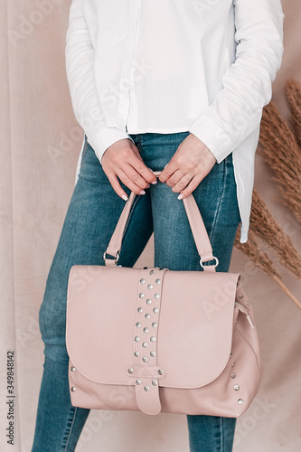 A girl in a white shirt and jeans holds a bag of bah-skin.