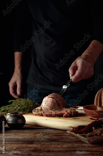 Chef prepare steak. Uncooked steak in sauce with spices an rosemary.