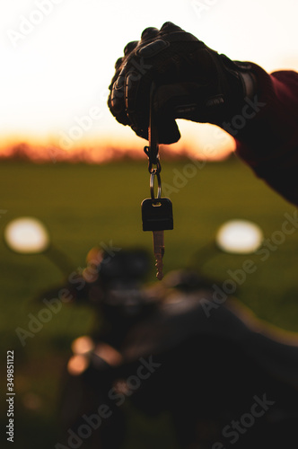 man holding a dark transport key on a background of motorcycles