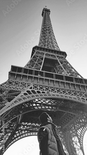 A ground view of a man looking at the Effeil Tower