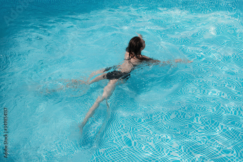 fashion photo of a sexy beautiful girl in elegant bikini posing and takes a sunbath in the swimming pool © ivancheremisin