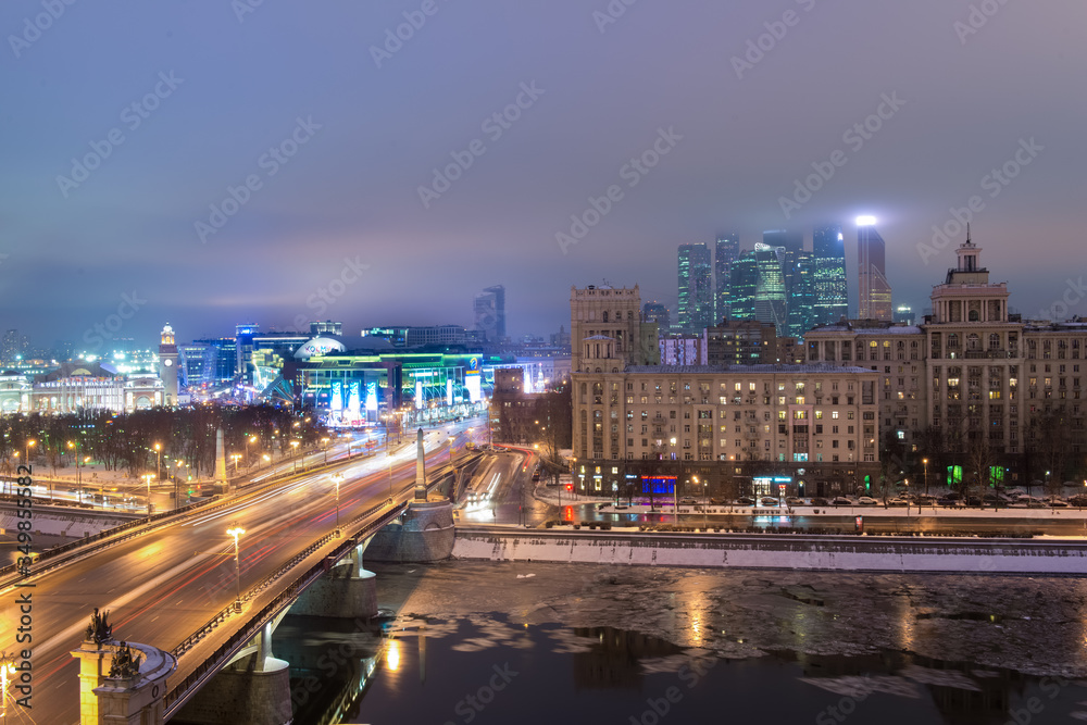 MOSCOW, RUSSIA - 4 JANUARY 2017: Night view to Borodinsky Bridge over the Moskva river, Evropeisky shopping mall and Moscow City international business center on background MOSCOW, RUSSIA - 4 JANUARY 2017: Night view to Borodinsky Bridge over the Moskva river, Evropeisky shopping mall and Moscow City international business center on background
