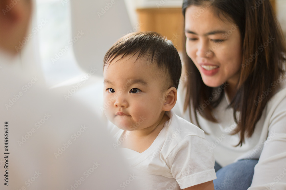 A mother enjoys playing with a baby in the home. A mother enjoys playing with a baby in the home.