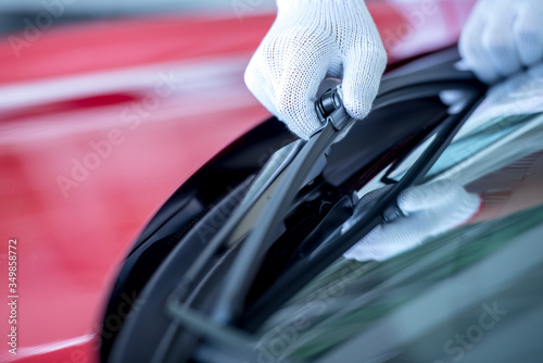 Billede på lærred The mechanic is changing the wipers in the parking lot