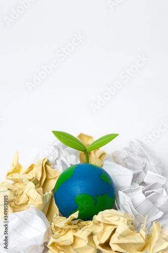green sprout on globe with garbage heap